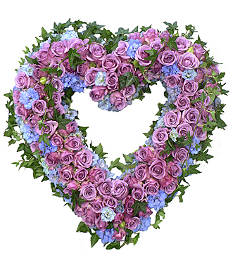 Blomsterhjärta av lila rosor och blå hortensia dekorerat med murgröna hos Bellis blomsterhandel.