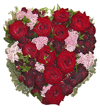 Blomsterhjärta i röda och rosa toner med bl.a. röda rosor, kvistrosor, murgröna hos Bellis blomsterhandel.